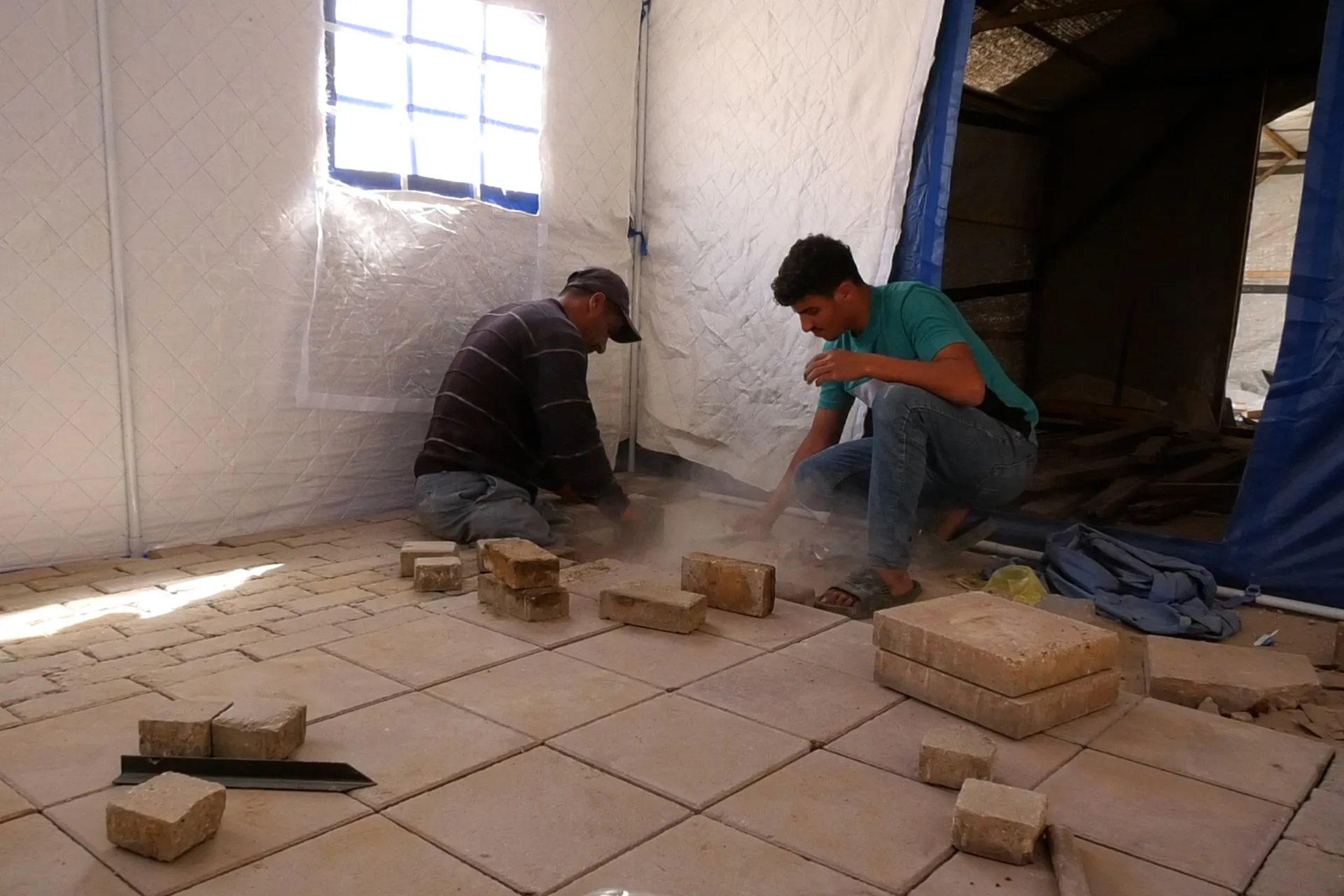 ابو جمال يتحدى الركام ببناء خيمة لغزة